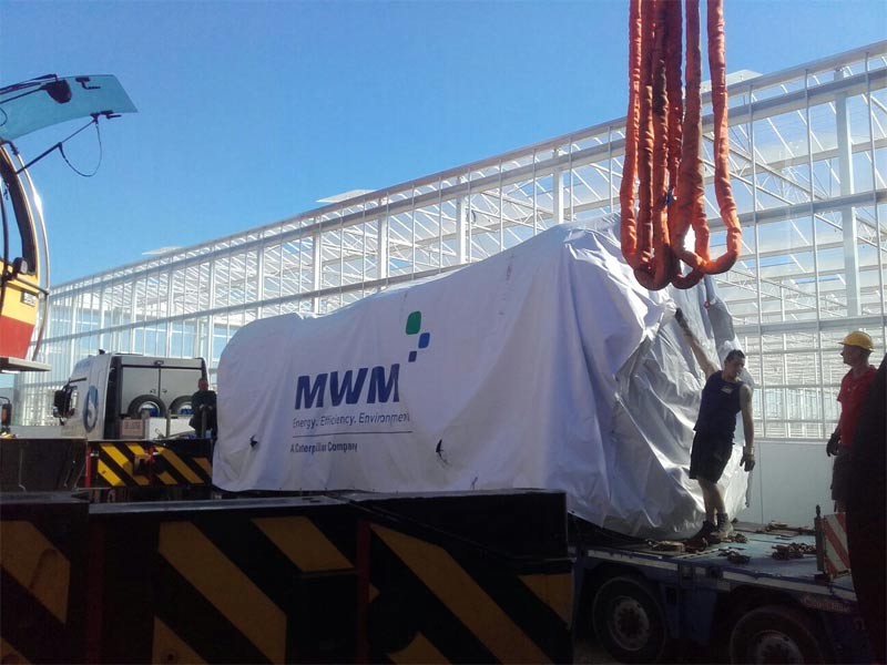 Разгрузка газовых двигателей MWM серии TCG 2032 перед возведённым зданием ТЭЦ для комбинированной выработки электрической и тепловой энергии